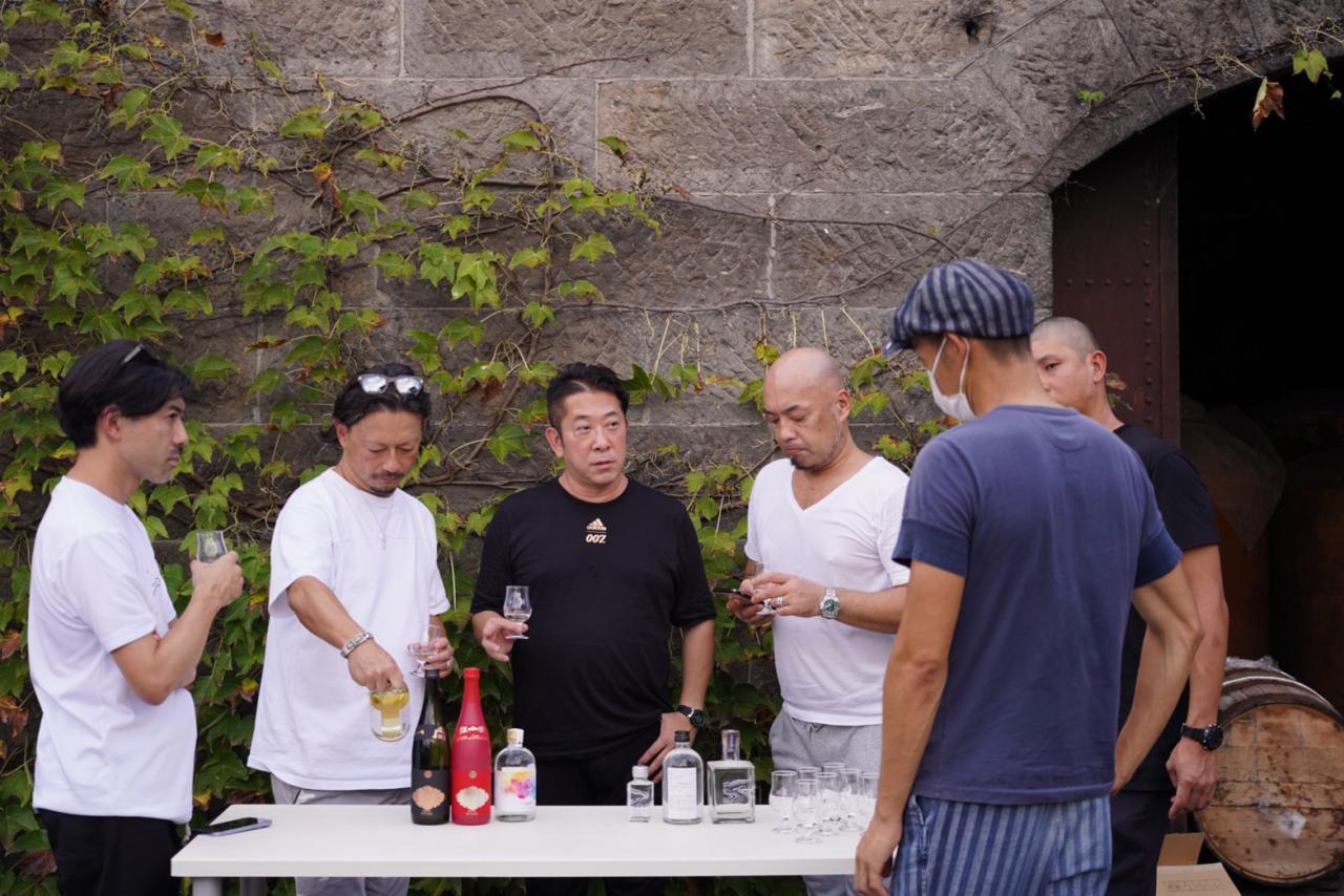 本田氏と大越氏を含めて、3人の料理人が木樽を熟成させる蔵の前でテイスティング。